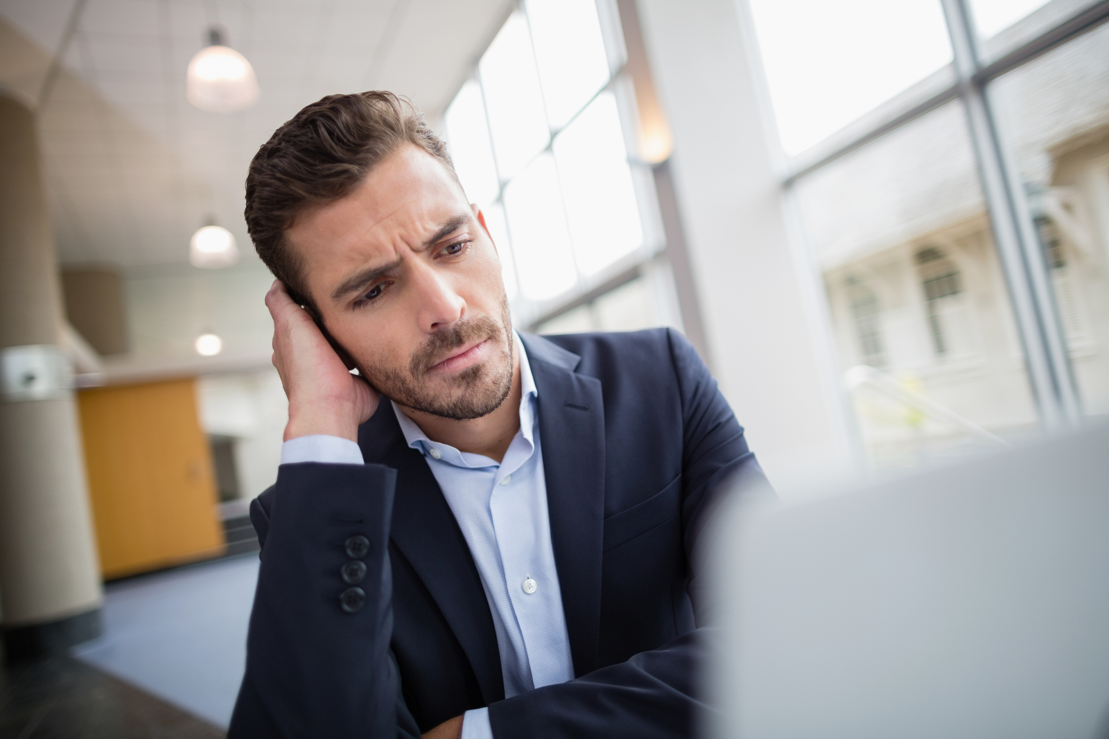 29322722 worried businessman sitting at desk with laptop