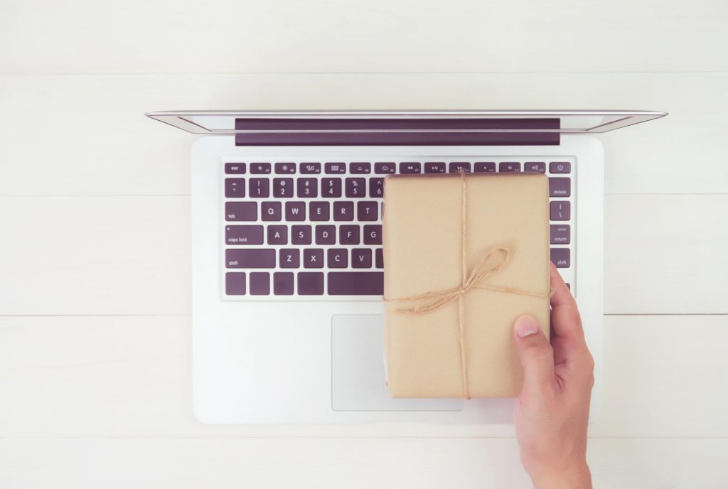 man holding reward on laptop